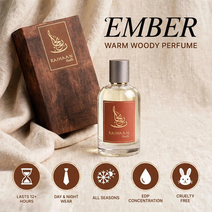 Raihaan Smiles Ember warm woody perfume bottle with a silver cap next to its wooden box, set against a draped beige fabric background with product feature icons at the bottom.