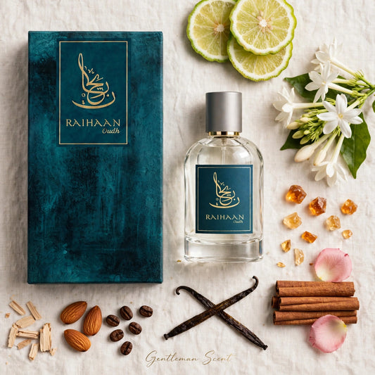 A clear rectangular perfume bottle with a silver cap and a dark teal label reading RAIHAAN scents, placed beside its matching teal box on a light fabric surface. The scene is styled with limes, white flowers, amber crystals, almonds, vanilla beans, cinnamon sticks, and pink petals.
